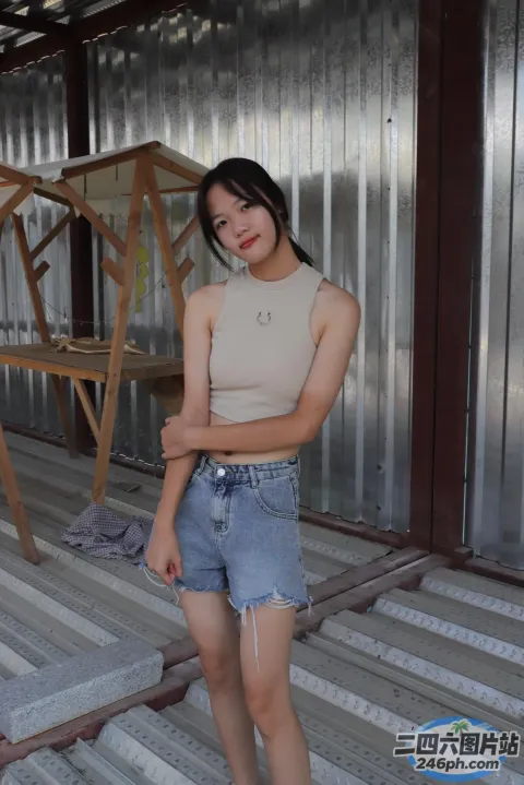 身穿棕褐色上衣和蓝色短裤的 Arafed 女子合影留念