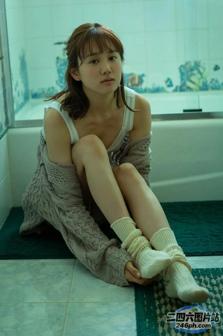 阿拉菲德女人坐在浴室的地板上，双腿交叉