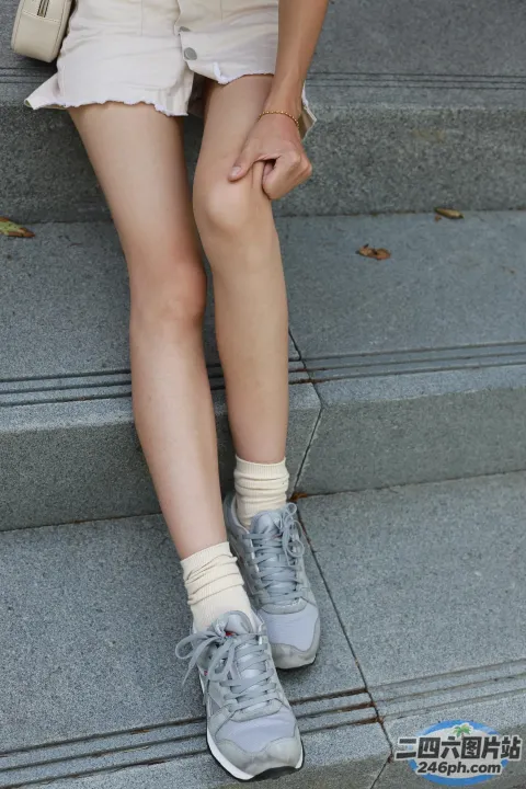 双腿交叉坐在台阶上的阿拉菲德女人