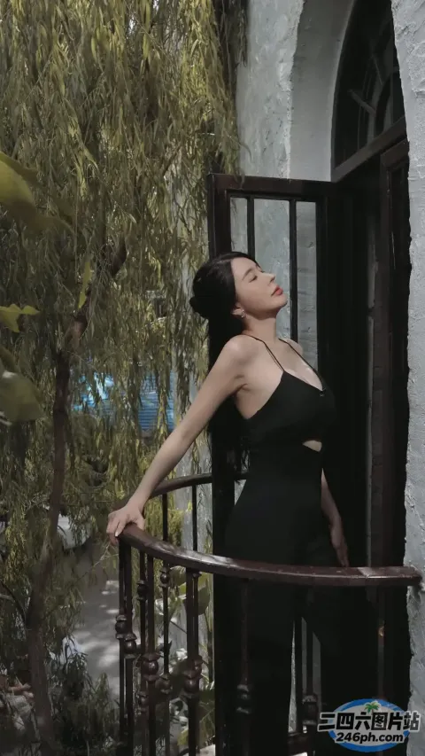 站在阳台上的黑裙 araffe 女子