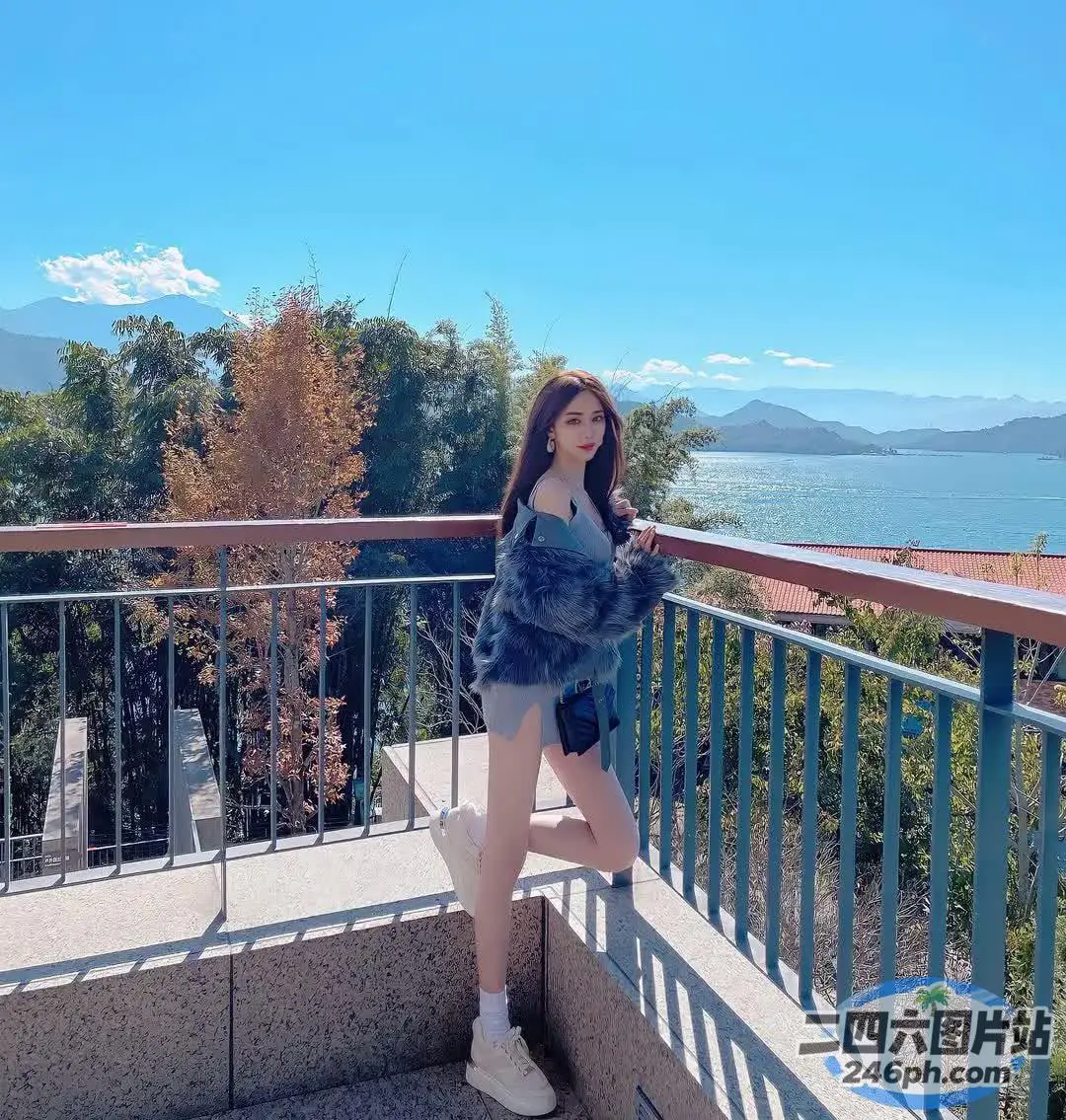 一个女人站在阳台上，可以看到水景