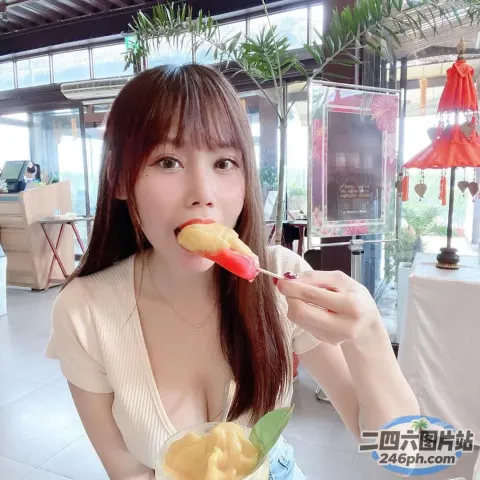 女人嘴里叼着叉子吃着一块水果