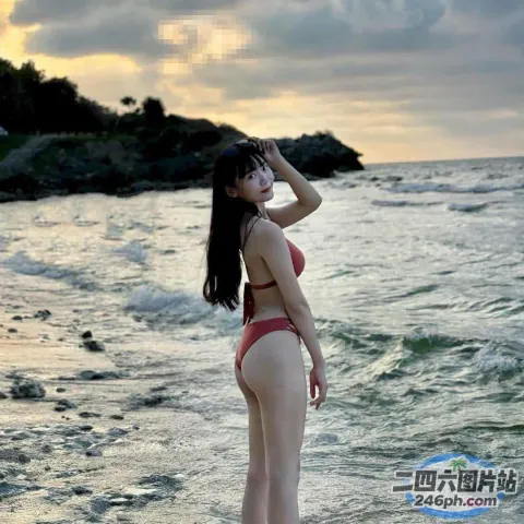 海滩上站着一个穿着红色比基尼的女人