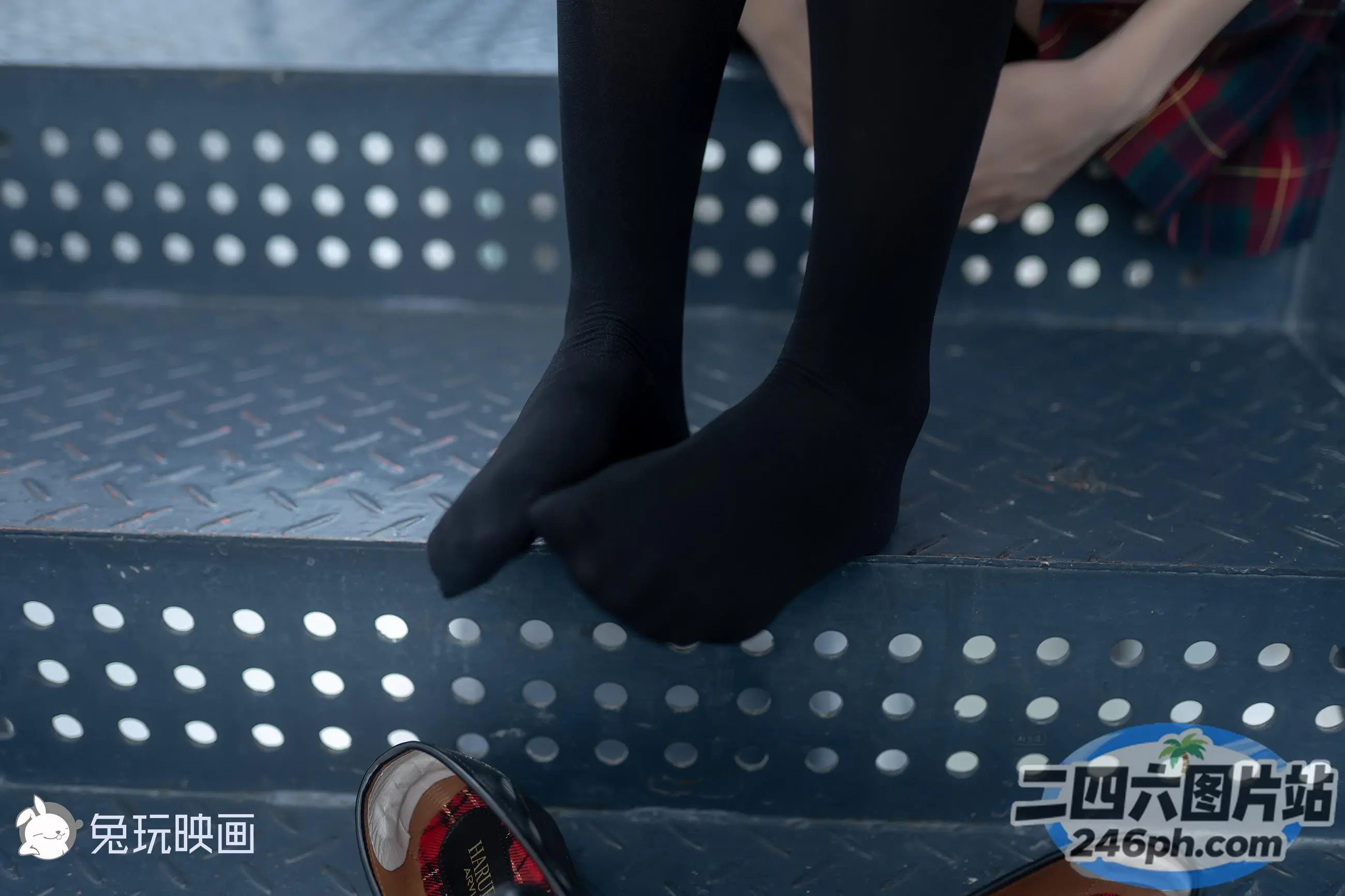 有一个女人坐在台阶上，脚踩在一双鞋上