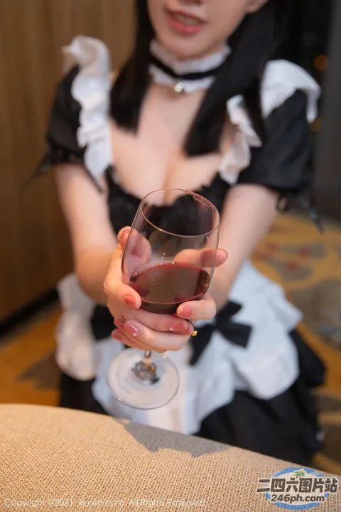 身穿女仆装的女子手里拿着一杯酒