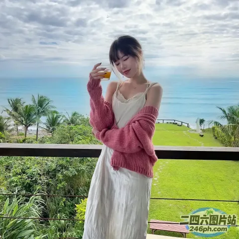 阳台上站着一个女人，手里拿着一杯酒