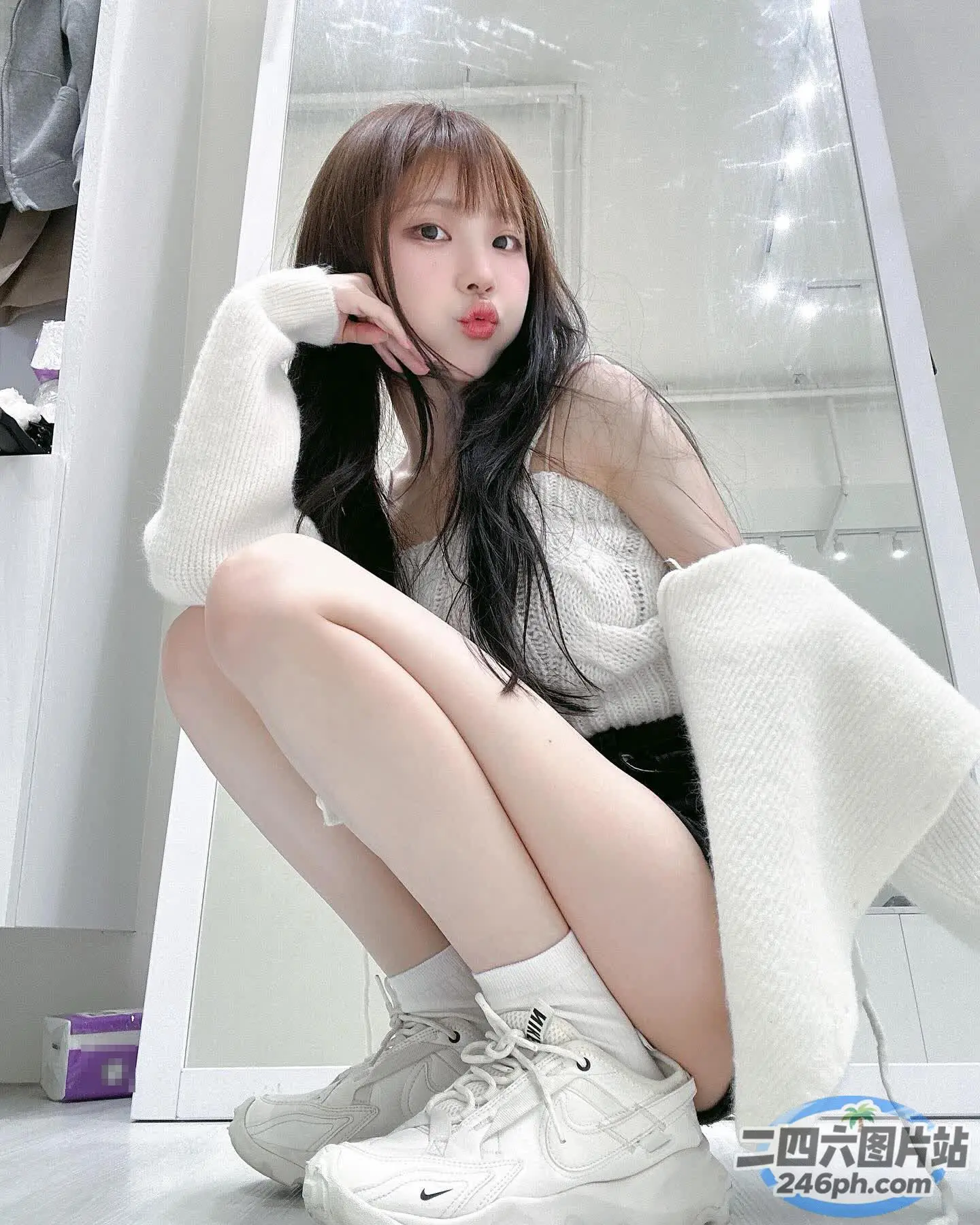 阿拉菲女孩双腿交叉坐在地板上