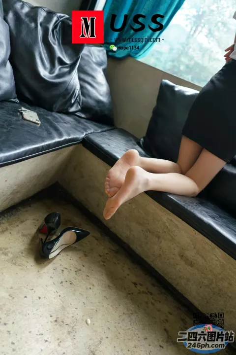 有一个女人坐在沙发上，双脚抬起