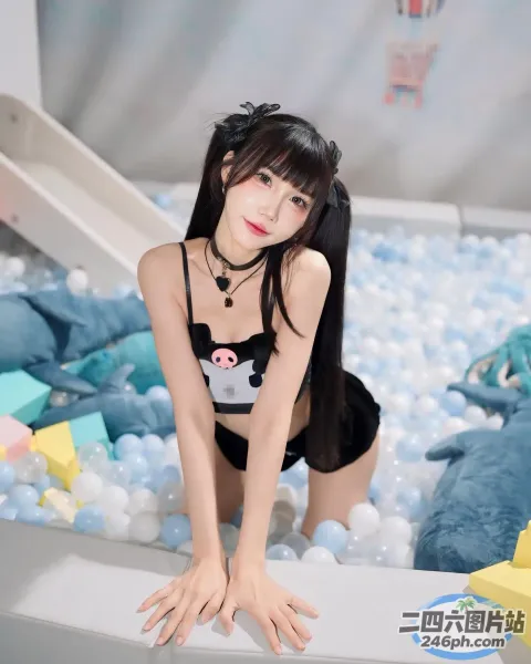 一个穿着黑色比基尼上衣和黑色短裤的女人在球坑里