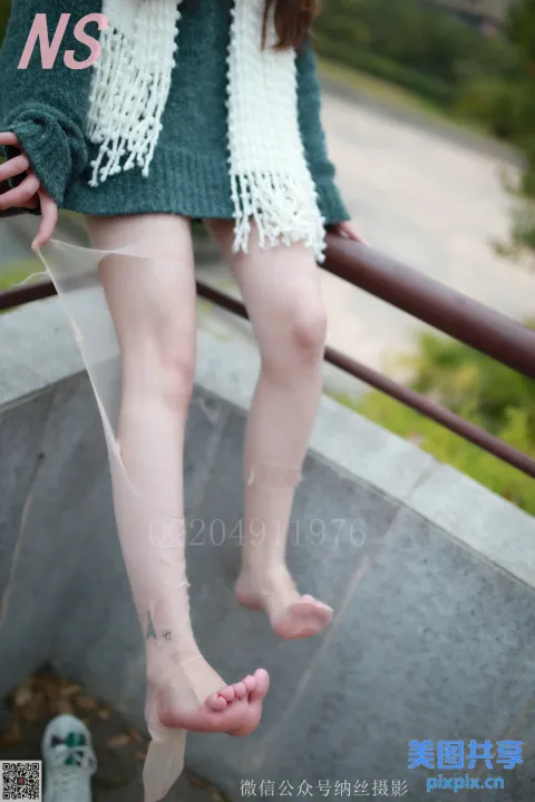 坐在栏杆上的女人的锯齿状腿