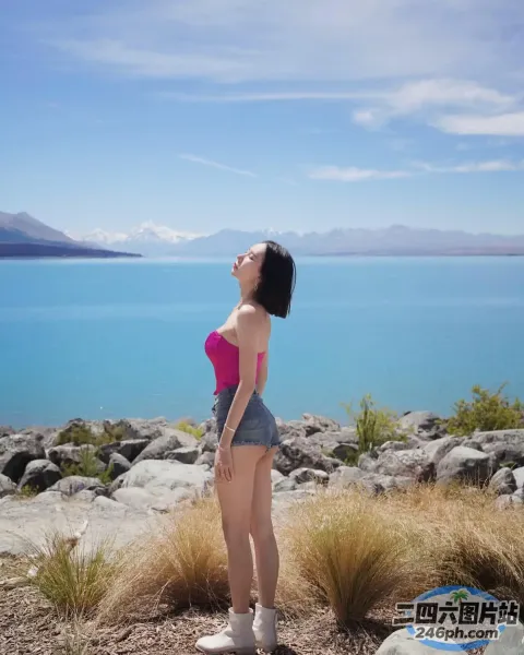 有一个女人站在岩石山上望着水