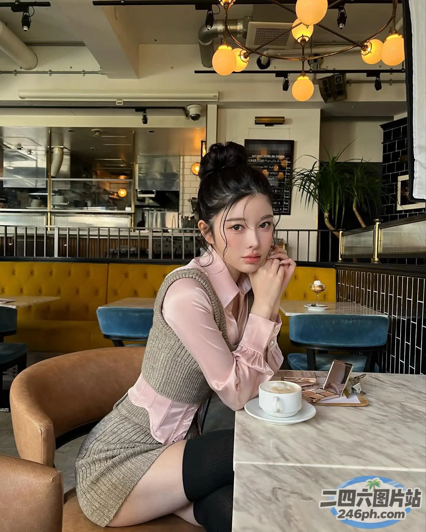 有个女人坐在桌子旁，手里拿着一杯咖啡