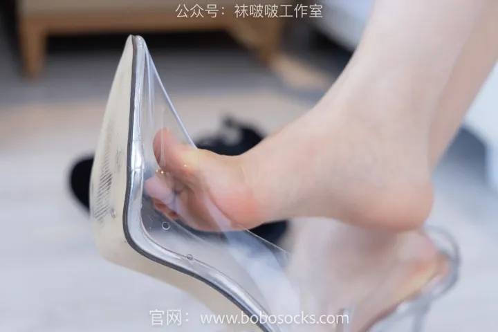 有人拿着一双鞋跟透明的鞋子