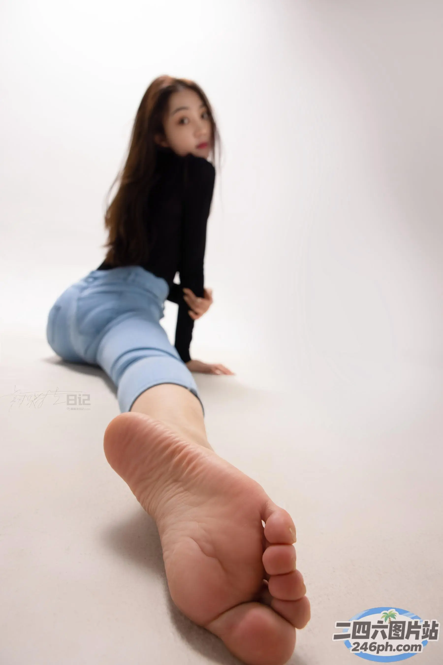 有一个女人坐在地板上，双脚抬起