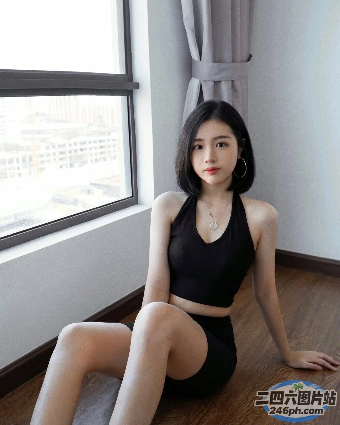一个女人坐在靠近窗户的地板上的特写