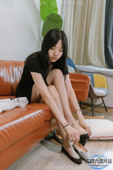 阿拉菲女人坐在沙发上，脚踩在书上