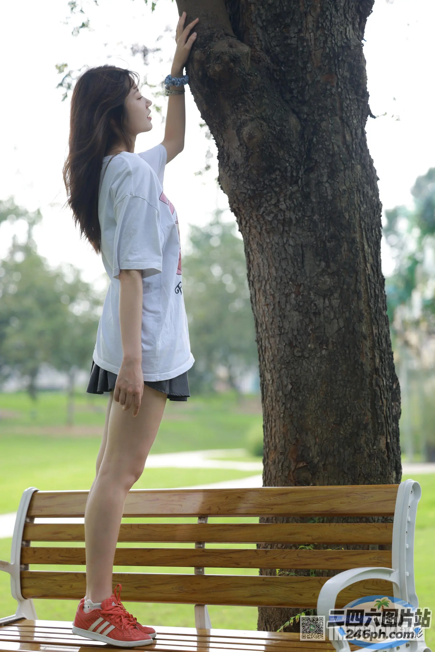 站在树旁长凳上的阿拉菲女人