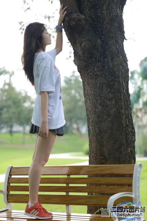 站在树旁长凳上的阿拉菲女人