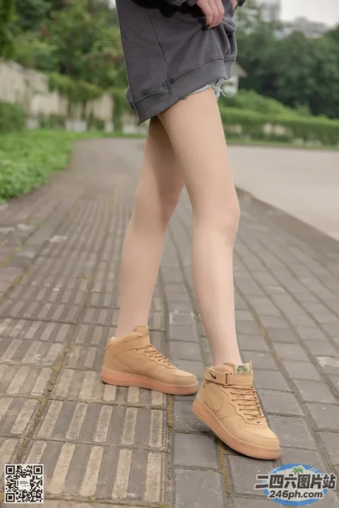 有个女人穿着鞋子站在砖砌的人行道上