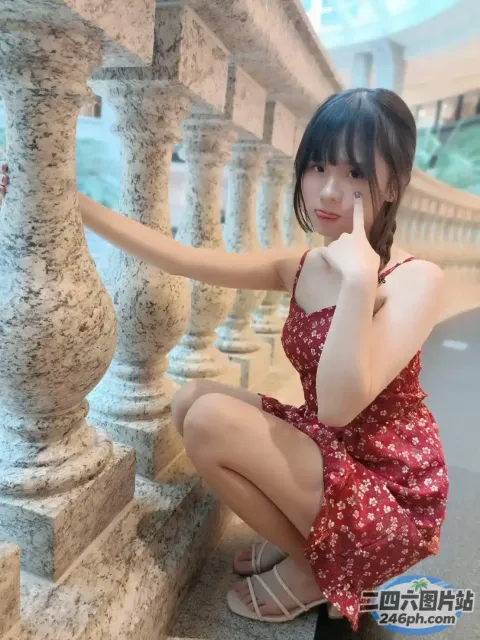 身穿红色连衣裙的 araffe 亚洲女子在石墙上摆姿势