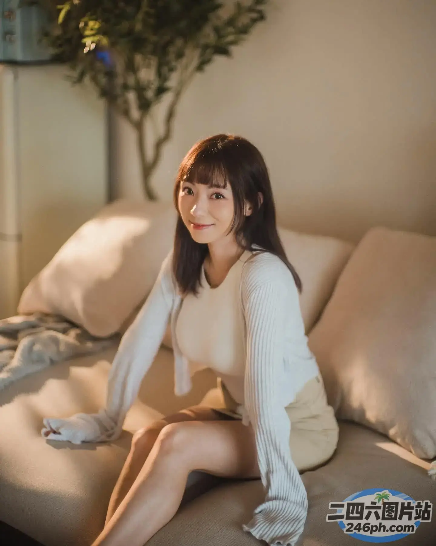 一个女人坐在沙发上拿着遥控器的特写