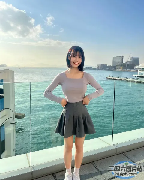 有一个女人站在俯瞰水面的阳台上