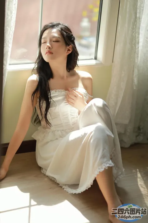 地板上坐着一个穿着白色连衣裙的女人