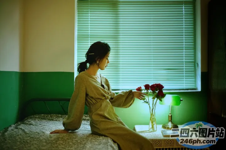 有一个女人坐在床上，手里拿着一瓶花