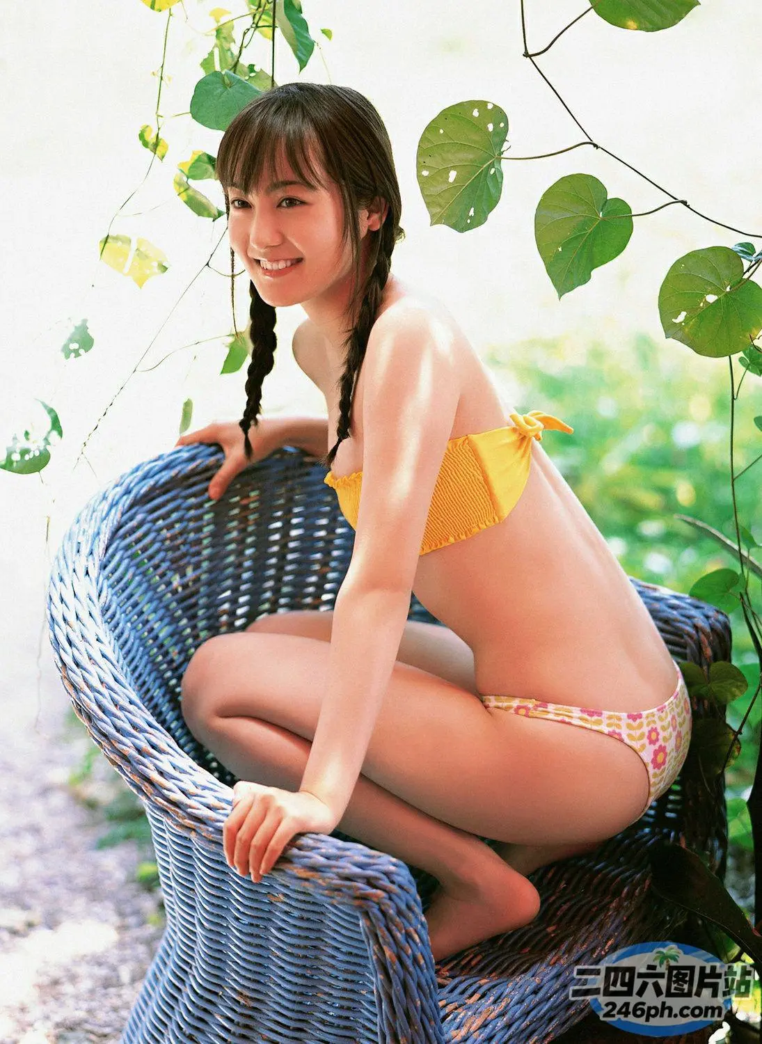穿着黄色比基尼坐在柳条椅上的 araffe 亚洲女性