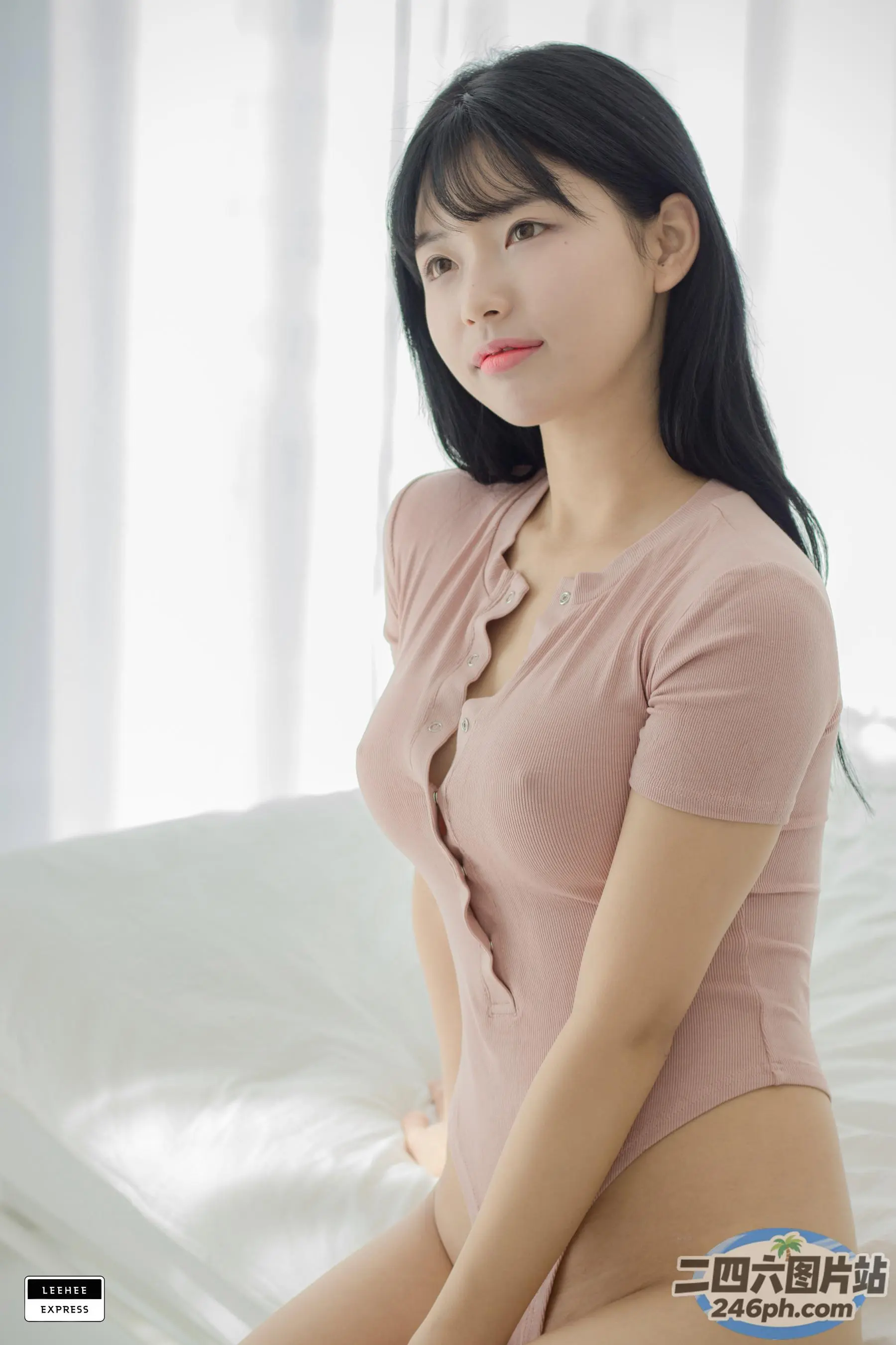 一个穿着粉红色衬衫的女人坐在床上