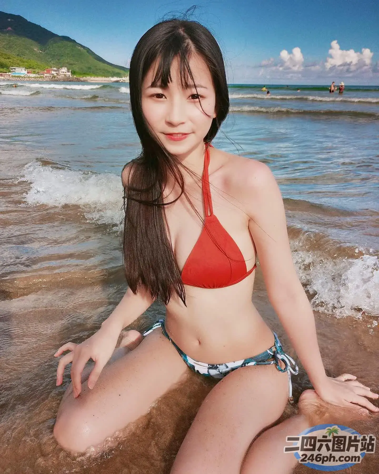 一个穿着比基尼的女人坐在海滩上的特写