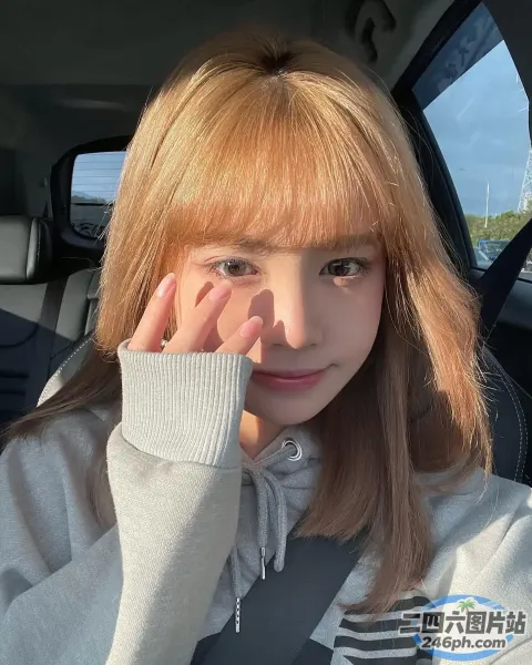 一名长发女子坐在车里，手捂着脸