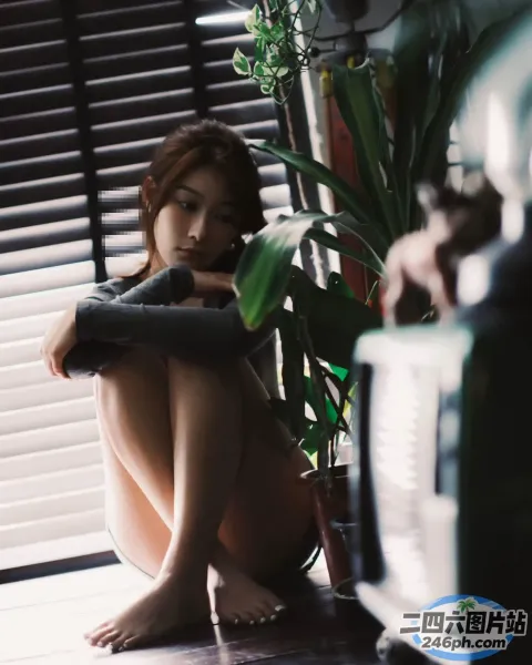窗前的地板上坐着一个女人