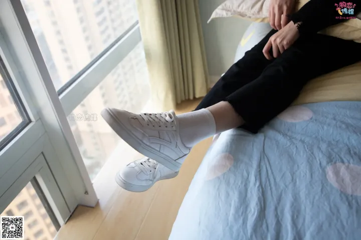 有人坐在床上，双脚抬起