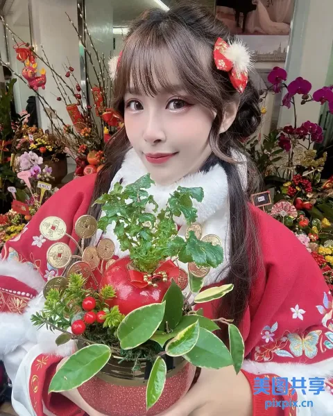 有一个女人拿着一个花盆，里面有一棵植物