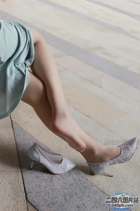 双腿交叉坐在长凳上的阿拉菲德女人