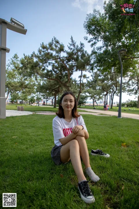 阿拉夫德女人坐在绿树成荫的公园里的草地上