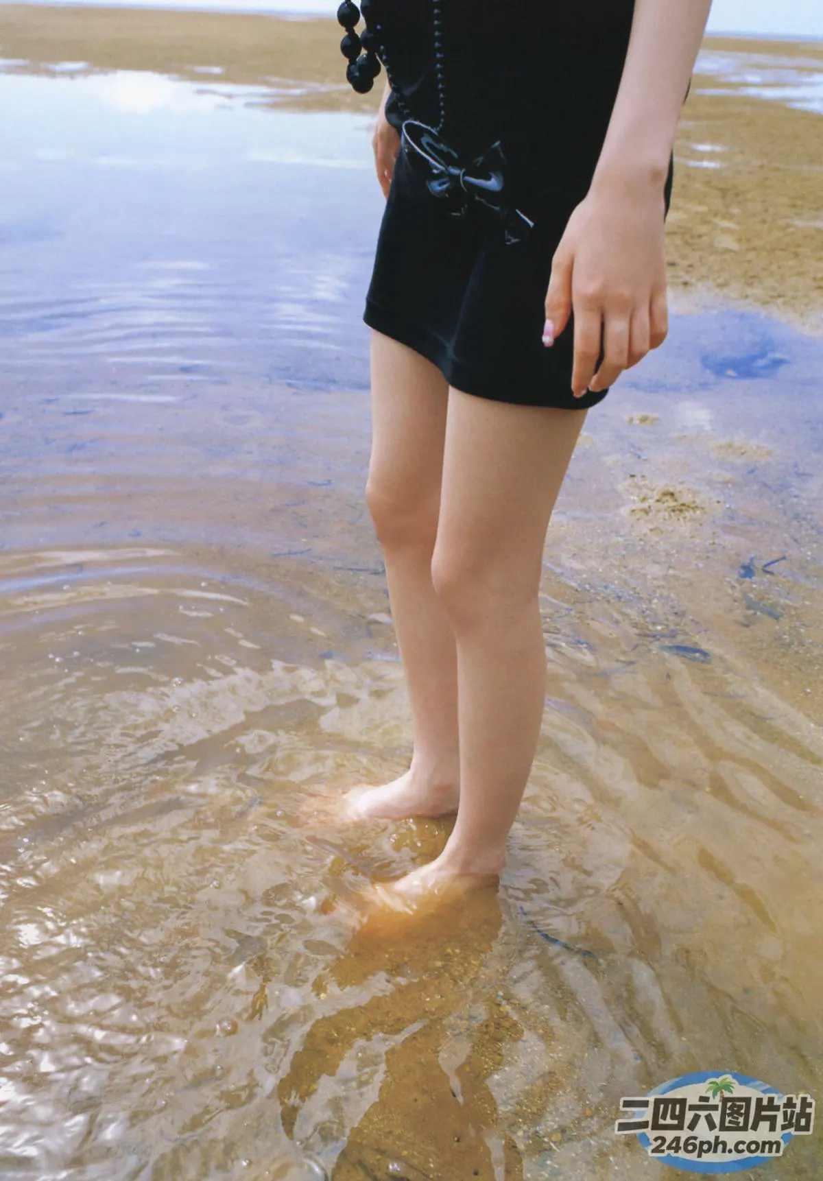 有一个女人站在水里，双脚在水中