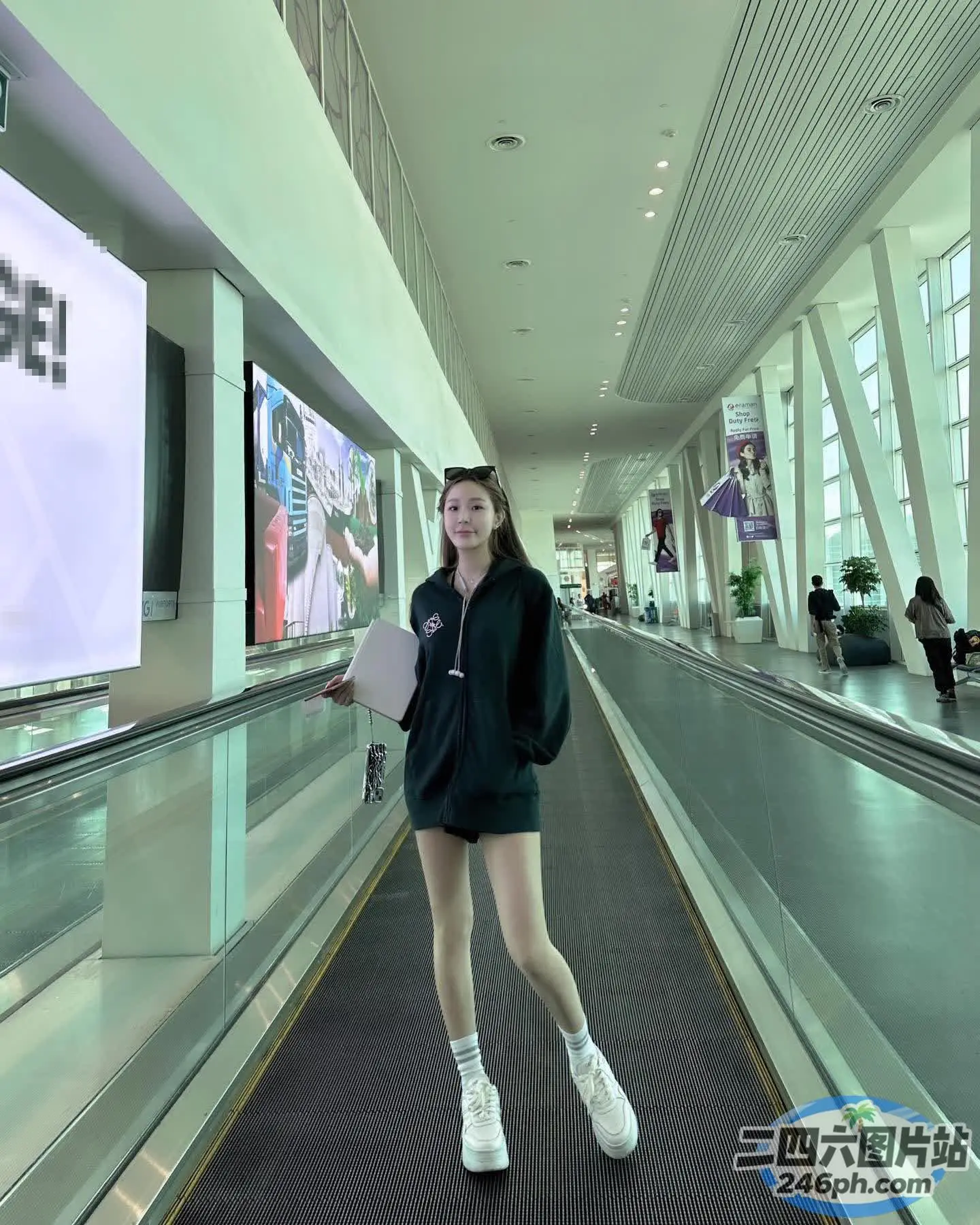 有一名女子站在建筑物的自动扶梯上