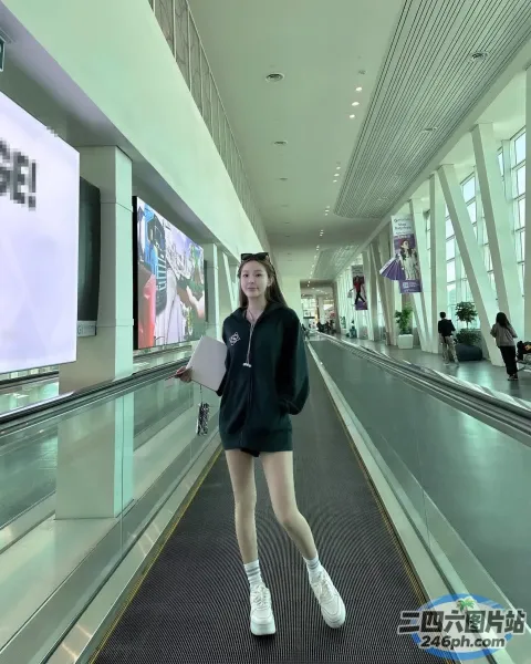 有一名女子站在建筑物的自动扶梯上