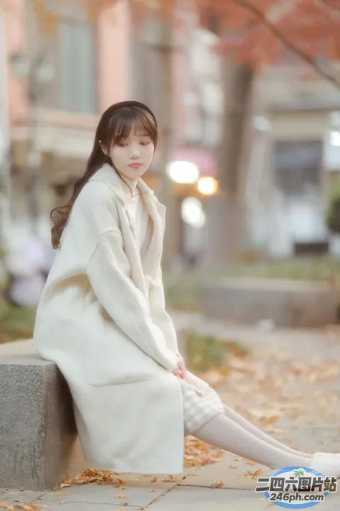 阿拉菲坐在公园的长椅上，手里拿着一本书