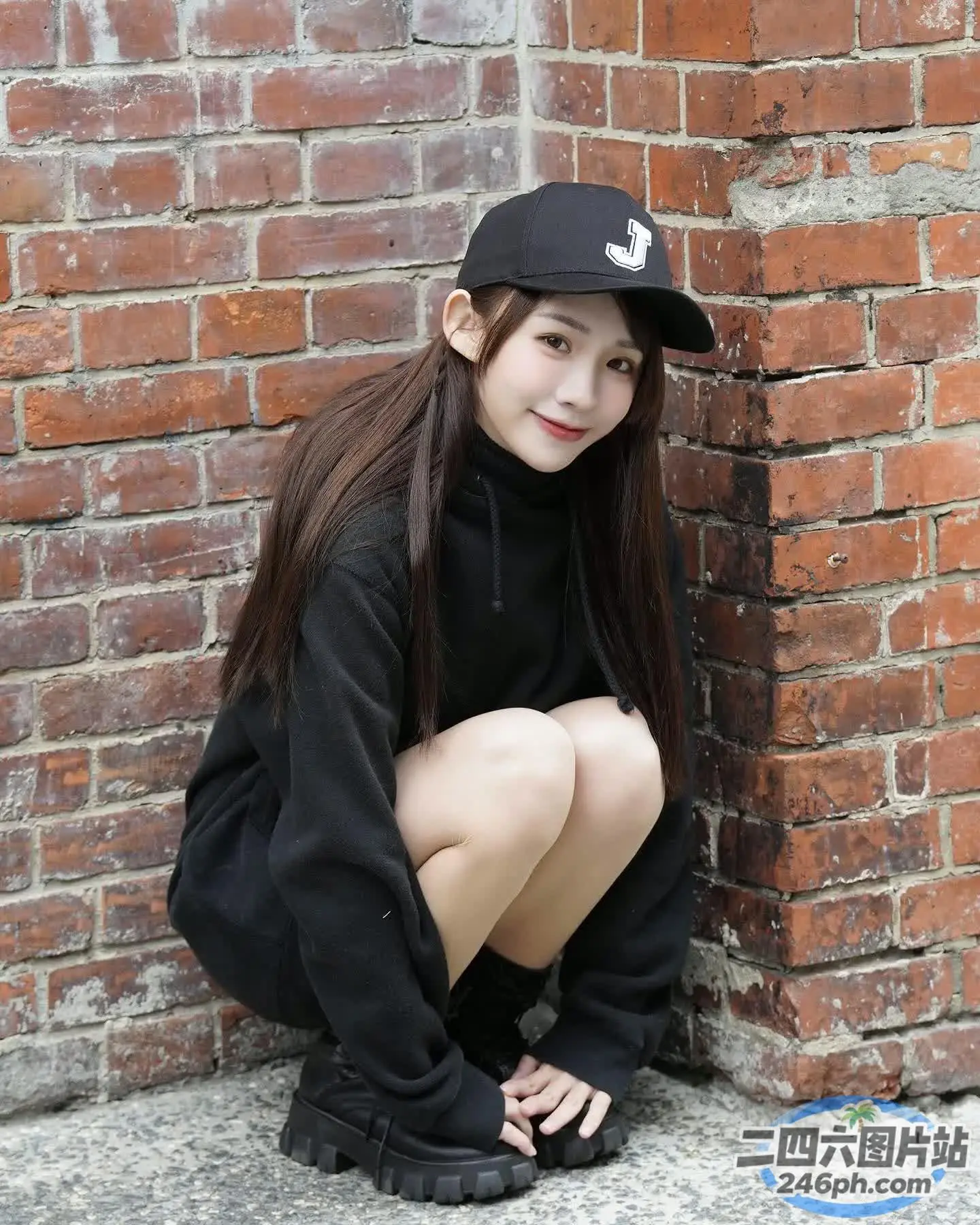 戴着帽子坐在地上的阿拉夫德亚裔妇女