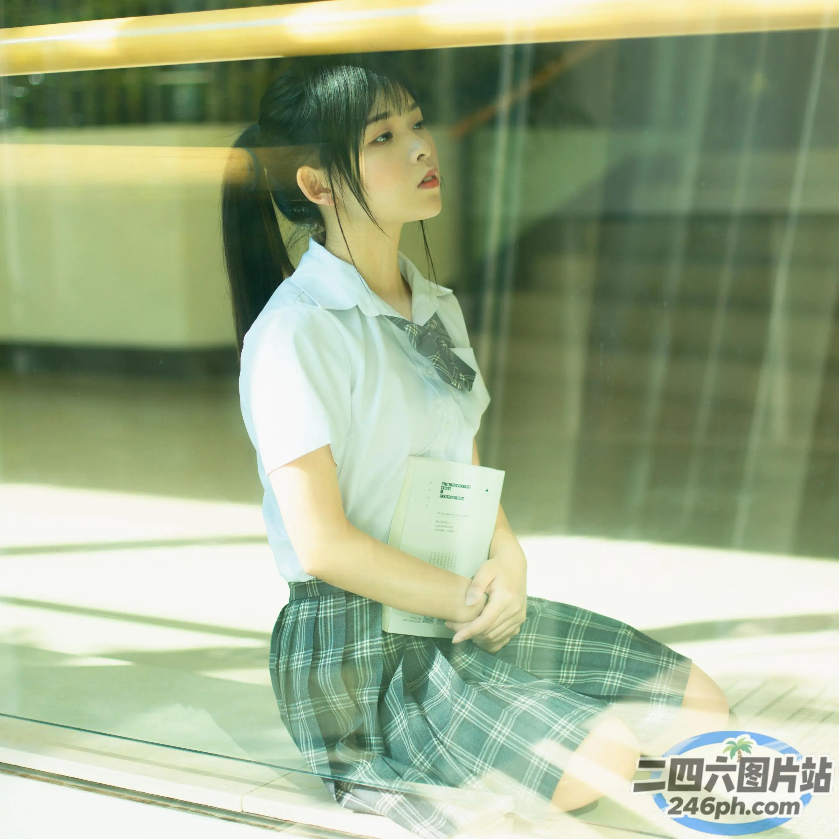 地上坐着一个女人，手里拿着一本书