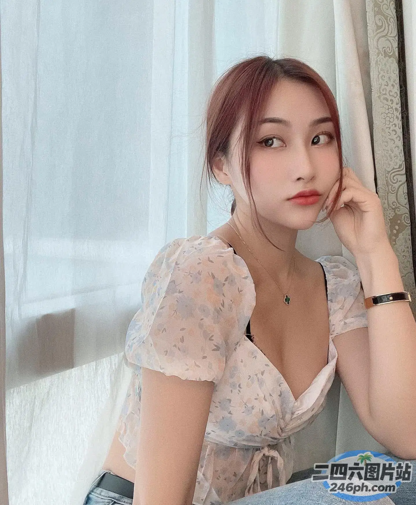 有个女人坐在椅子上，手放在下巴上