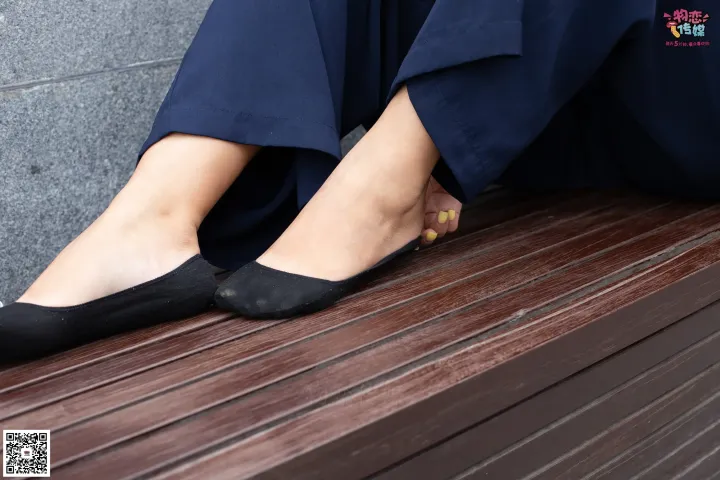 有个女人坐在长凳上，双脚放在长凳上