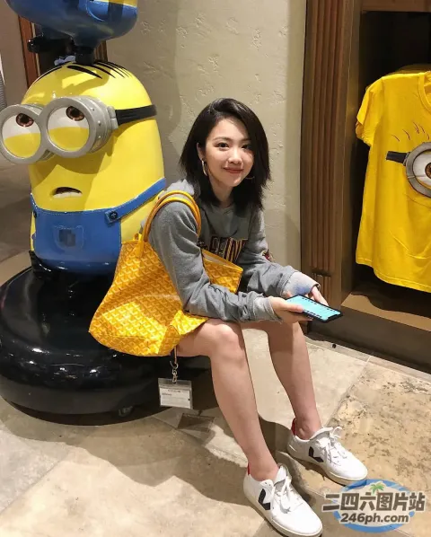 阿拉夫德女人坐在一个小黄人雕像旁边的凳子上