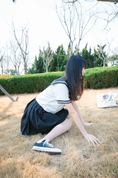 有一个女人跪在地上和一只猫玩耍