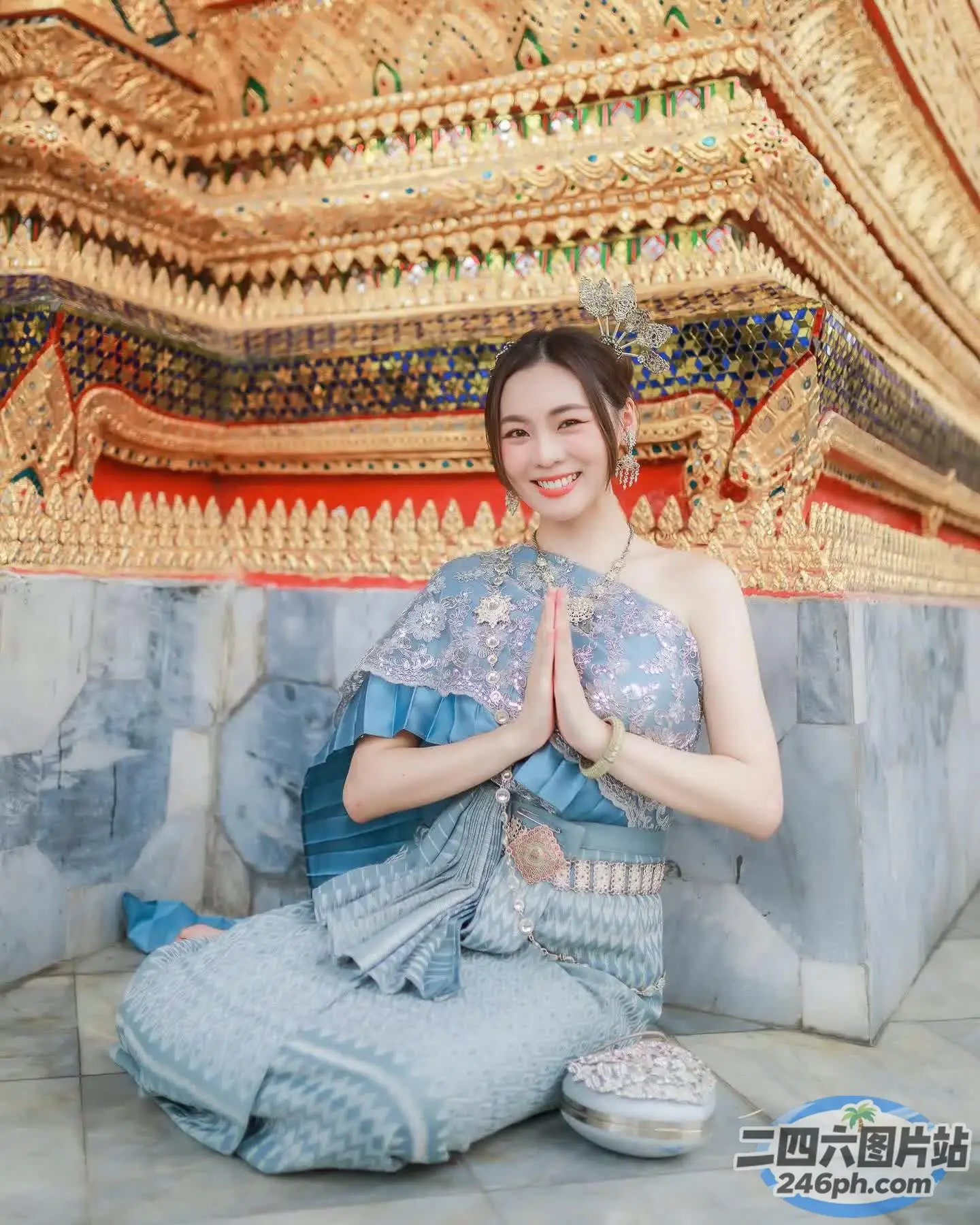 坐在瓷砖地板上的蓝色连衣裙的 Araffe 女子