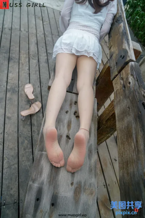 有个女人坐在长凳上，双脚抬起