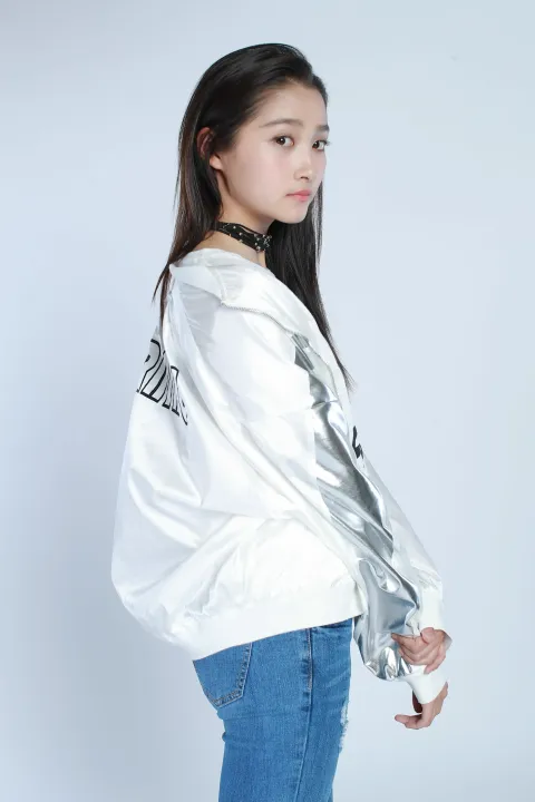 身穿白色夹克和牛仔裤的阿拉夫女子摆姿势拍照